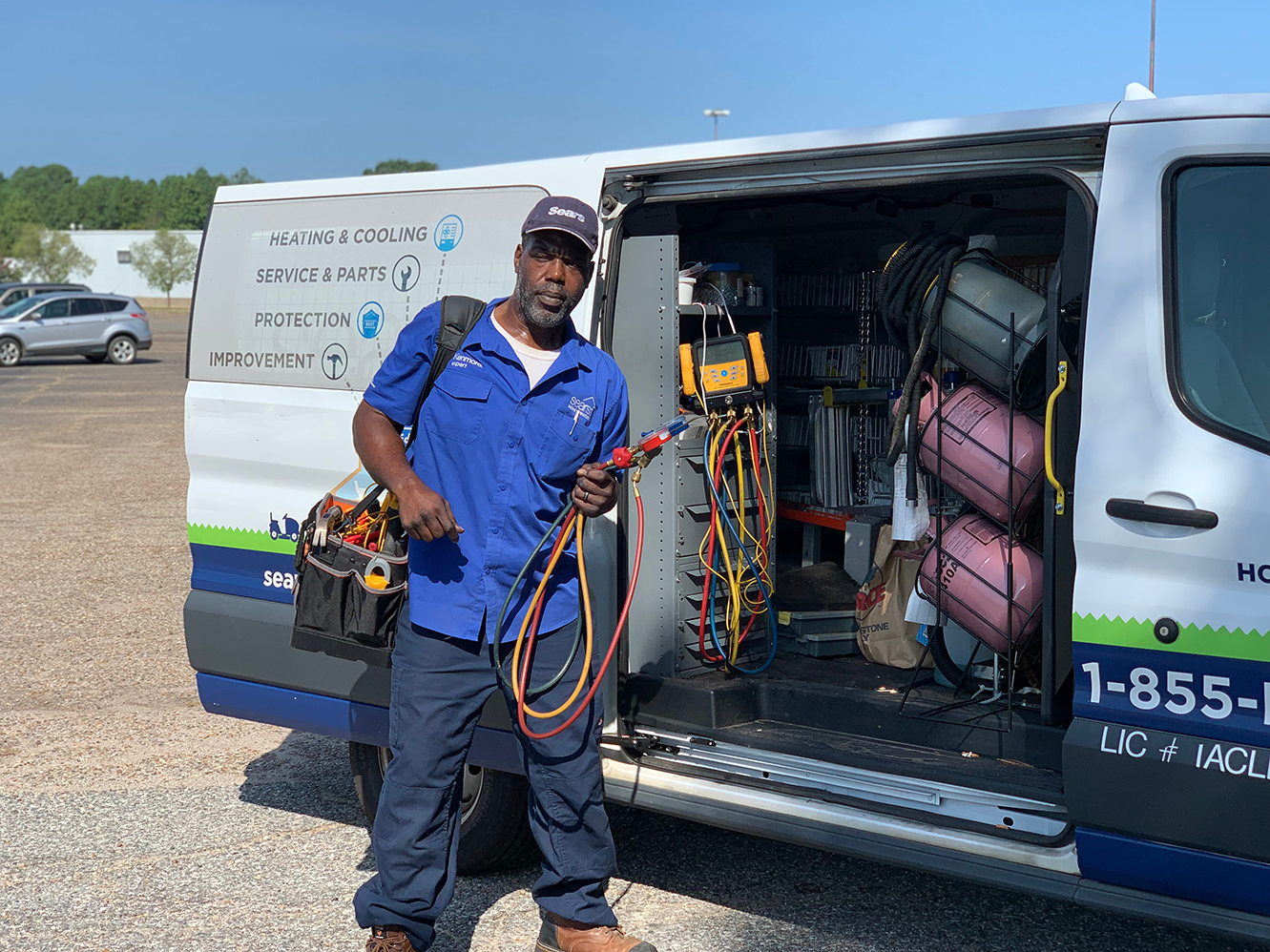 HVAC technician holding wires in front of open van