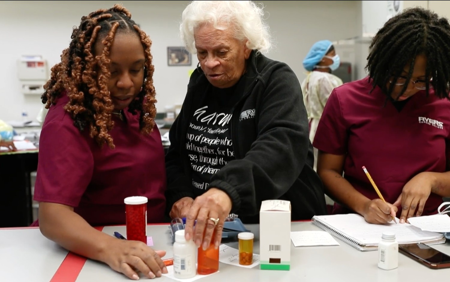 Pharmacy tech instructor helping a student count medicine